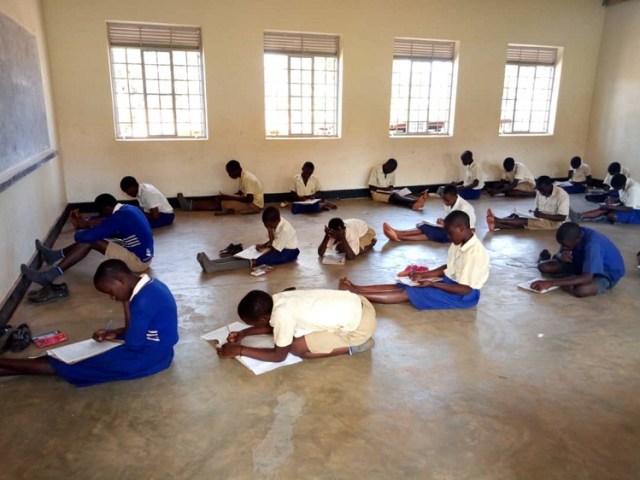 Children sitting on the floor before the donation was made.