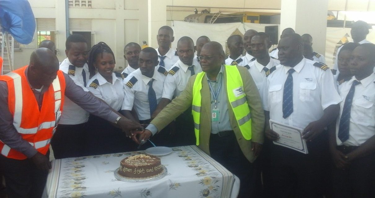 Deputy managing Director Civil Avian Authority (CAA) Fred Bamwesigye joins fire fighters and marine rescue trainees to cut the cake during their pass out at the Entebbe International Airport last Friday