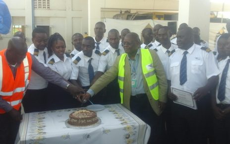 Deputy managing Director Civil Avian Authority (CAA) Fred Bamwesigye joins fire fighters and marine rescue trainees to cut the cake during their pass out at the Entebbe International Airport last Friday