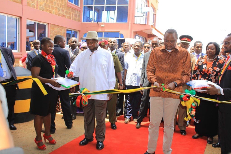 Uganda President Yoweri Museveni and his Kenya counterpart Uhuru Kenyatta cutting a ribbon in a recent function at the Busia border post as part of their mission to boost trade between the two countries at the one stop border post