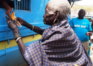 Teko Okudo recieving money from the mobile bank van in Moroto