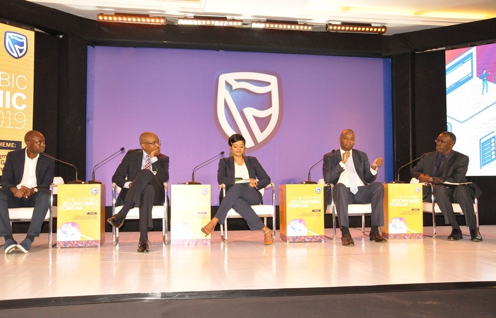 Patrick Mweheire, Stanbic Bank Uganda Chief Executive (2nd Right) responds to one of the questions paused during the panel discussion at the 2019 Stanbic Economic Forum as Paul Busharizi, Public Editor, New Vision (1st Right), Rashmi Pillai, Financial Sector Deepening Uganda Direct of Programs (Centre), Micheal Nyitegeka, ICDL Africa Country Manager (2nd Left), Edgar Kasenene, heat of IOT (1st Left) look on.