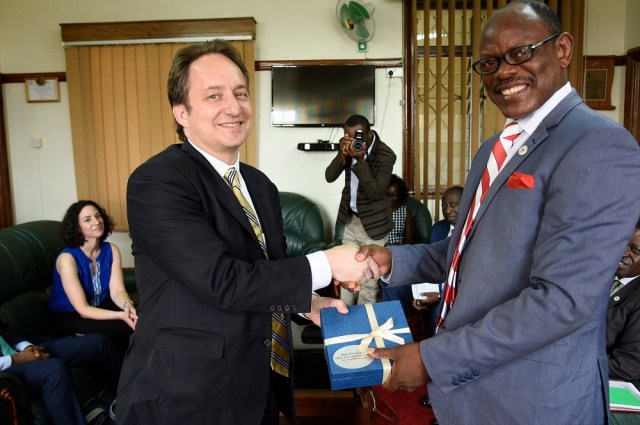 Yale University’s Vice President, Pericles Smith (L) hands over a present to Makerere University Vice Chancellor Prof. Barnabas Nawangwe at Makerere University during an official visit in Uganda on March 13, 2019. This was during the Yale’s stuff visit to meet the university Alumni and partners