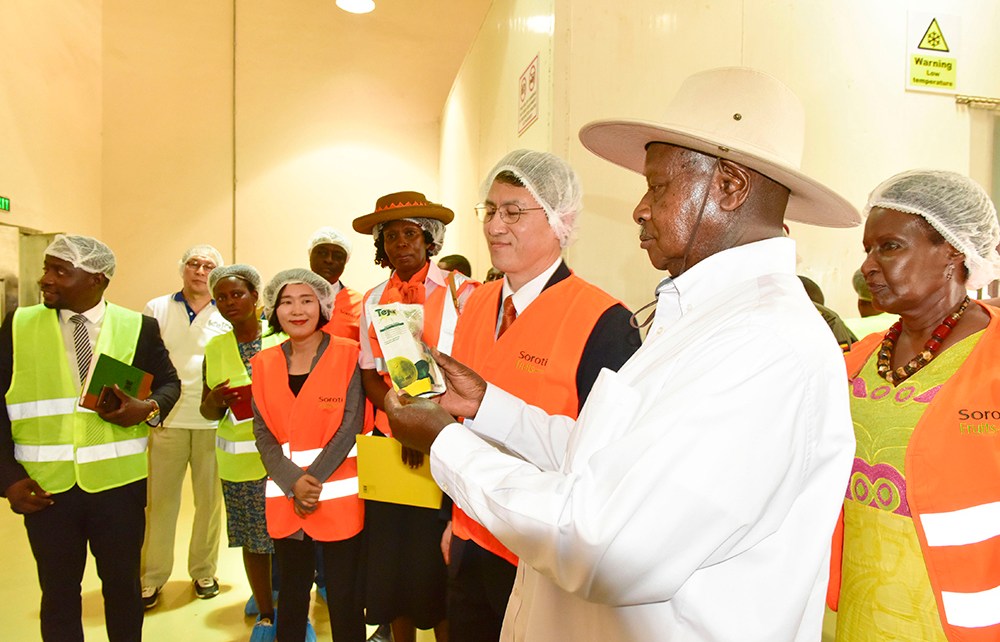 President Museveni accompanied by Trade and Industry Minister Amelia Kyambadde (R) looks at one of the processed and packaged products of Soroti Fruit Factory during the commissioning on Saturday April 13, 2019