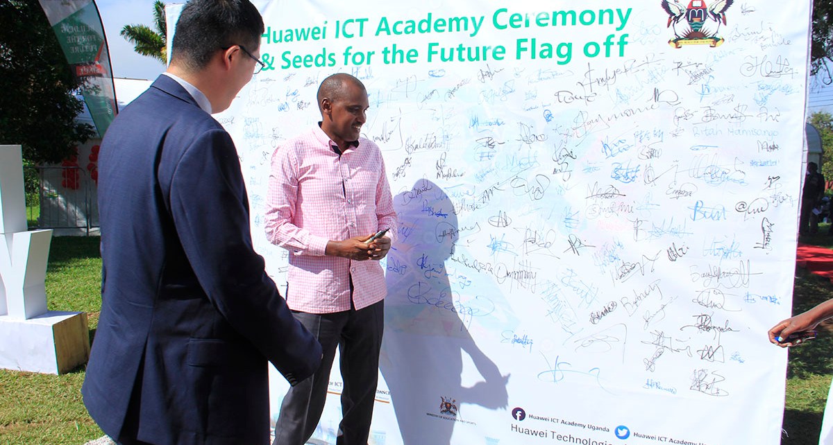 The ICT Minister Hon Frank Tumwebaze making an autograph at the ICT Academy Ceremony