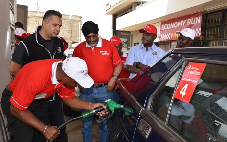Micky Bassi (centre) watches Total Excellium Economy Run officials fill his Alfa 75 sports saloon at the finish of the 2018 event which he won. Bassi will defend his title this year on June 22nd.