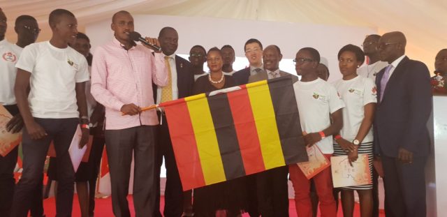 Uganda's Minister for ICT and National Guidance Frank Tumwebaze waves National Flag to flag off the 2019 Uganda Seeds for the Future Program Students to China. This was at Makerere University in Kampala.