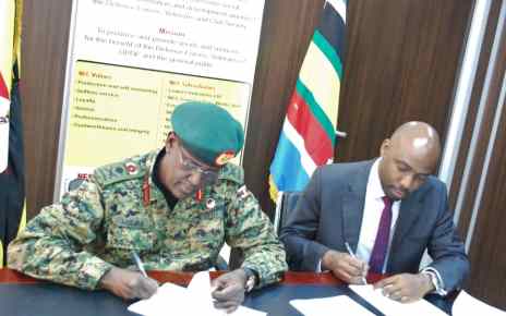 Managing Director of NEC, Lt Gen. James Mugira, (Left) and Executive Director of UFZA Richard Jabo (Right) pens down the deal at NEC offices in Bugolobi, Kampala recently