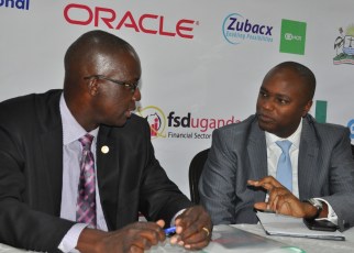 Wilbrod Owor, the Uganda Bankers Association Executive Director and the Association's Chairman Patrick Mweheire have a chat during a press briefing to announce `the 3rd Annual Bankers Conference slated for 16th July.