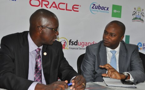 Wilbrod Owor, the Uganda Bankers Association Executive Director and the Association's Chairman Patrick Mweheire have a chat during a press briefing to announce `the 3rd Annual Bankers Conference slated for 16th July.