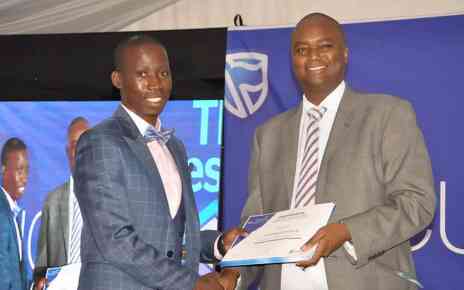 Stanbic Chief Executive Patrick Mweheire hands over a certificate to one of the entrepreneurs who completed training at the Stanbic Bank Incubator