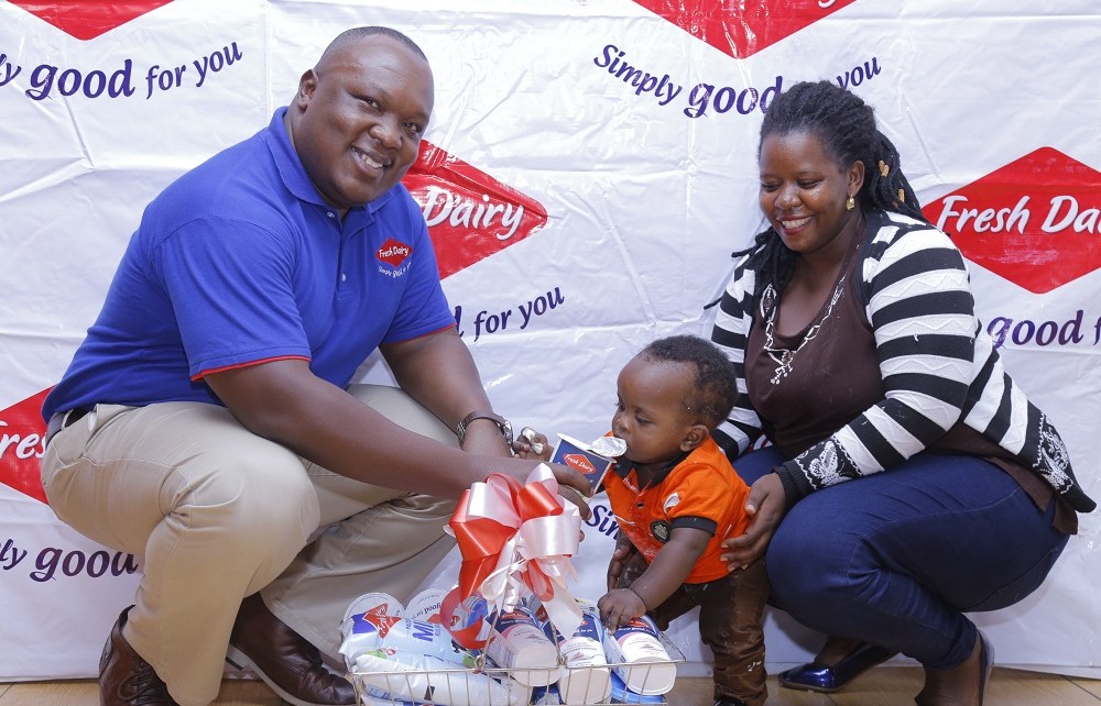 Vincent Omoth Marketing Manager Fresh Dairy (Left) hands over an assortment of Fresh Dairy products to Nellywn Ahirweomugisha (Centre) and his mother (Right).