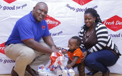 Vincent Omoth Marketing Manager Fresh Dairy (Left) hands over an assortment of Fresh Dairy products to Nellywn Ahirweomugisha (Centre) and his mother (Right).