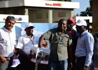 Tushar Mashru (2nd L), Total Uganda dealer, Richard Jjuko, (C) Total Wampewo Station Manager, with a customer picking a raffle ticket during the Total Uganda “Extra Mile” promotion on 2nd November 2018 at Total Wampeewo station. Lucky Winners of the draw will get free full-year car service.