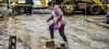 A woman walks across a flooded road in Santo Tomás, San Salvador, after Tropical Storm Amanda caused a landslide.